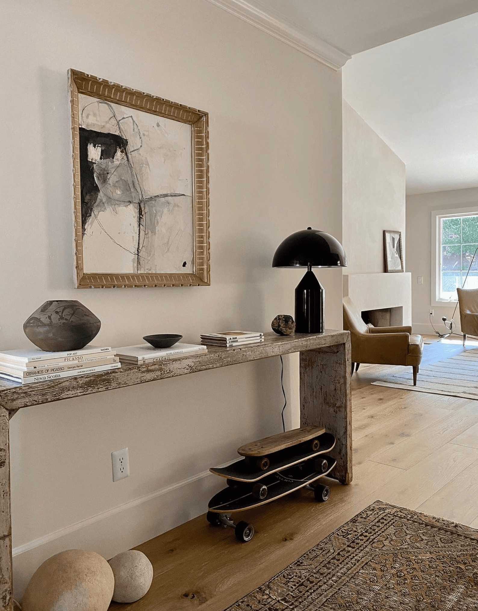 long console table in entryway with art and a lamp 
