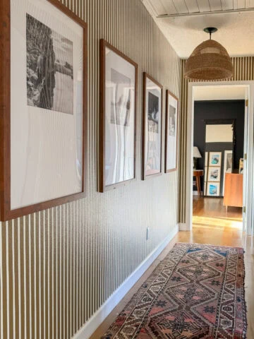 brown and white striped hallway with travel photo frames